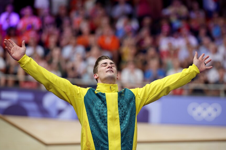 Matthew Glaetzer stands with his arms outstretched