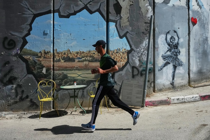 A runner runs past a table and chairs