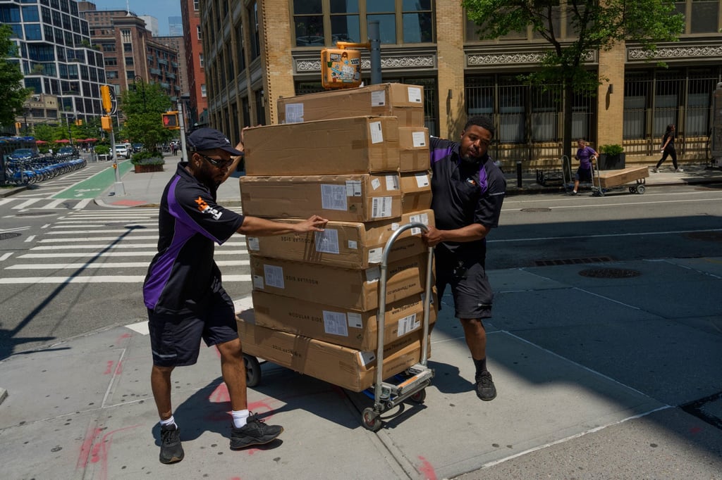 Workers move packages on Tuesday in New York. Photo: AP Workers move packages on Tuesday in New York. Photo: AP