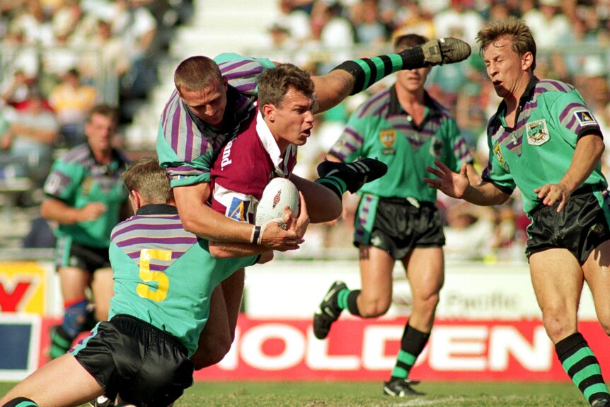 A man runs the ball during a rugby league match