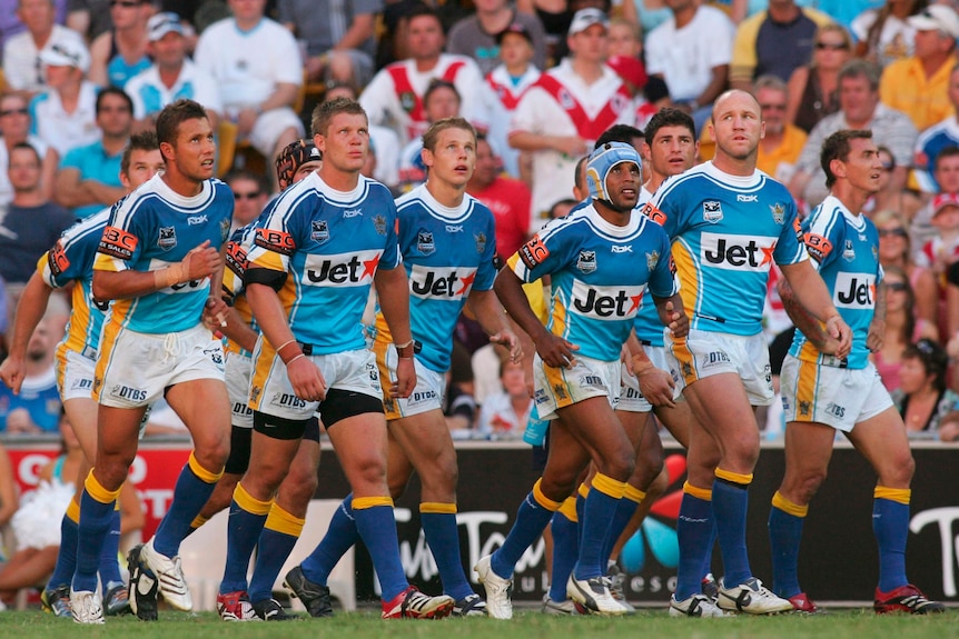A group of players watch a conversion go over during a rugby league match