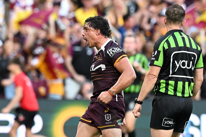 A man celebrates after scoring a try in a rugby league match 