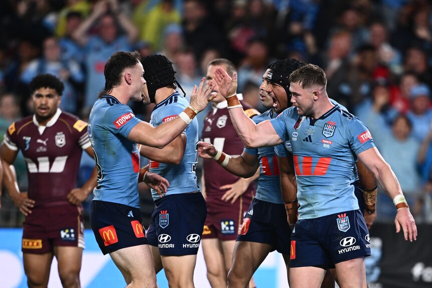 Two NSW players celebrate a try in a State of Origin match.