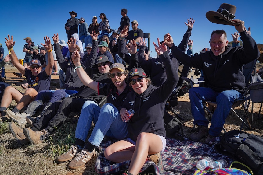 A crowd of spectators cheering from the sidelines.