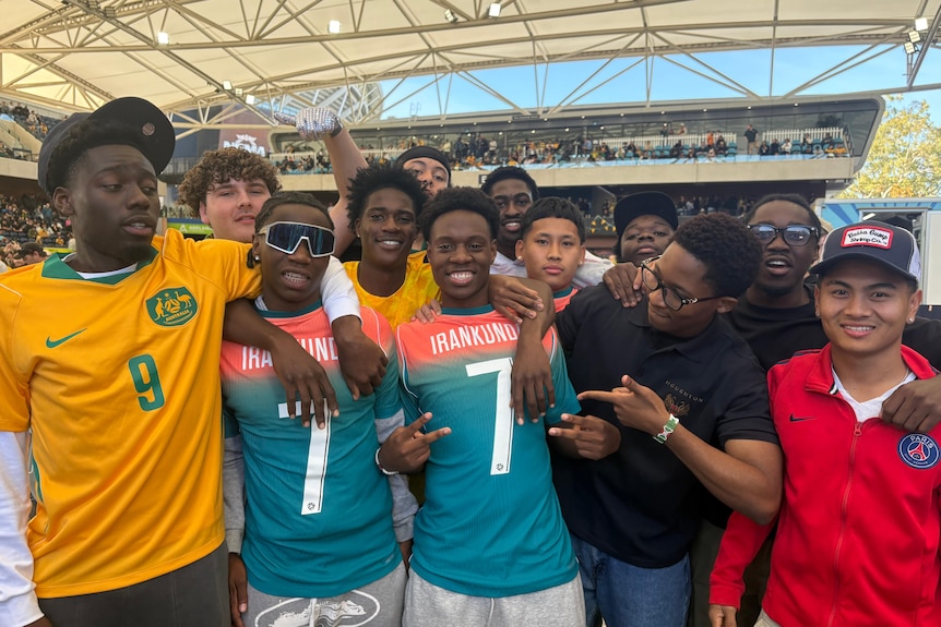 a group of teens wearing Irankunda fan shirts smile at the camera