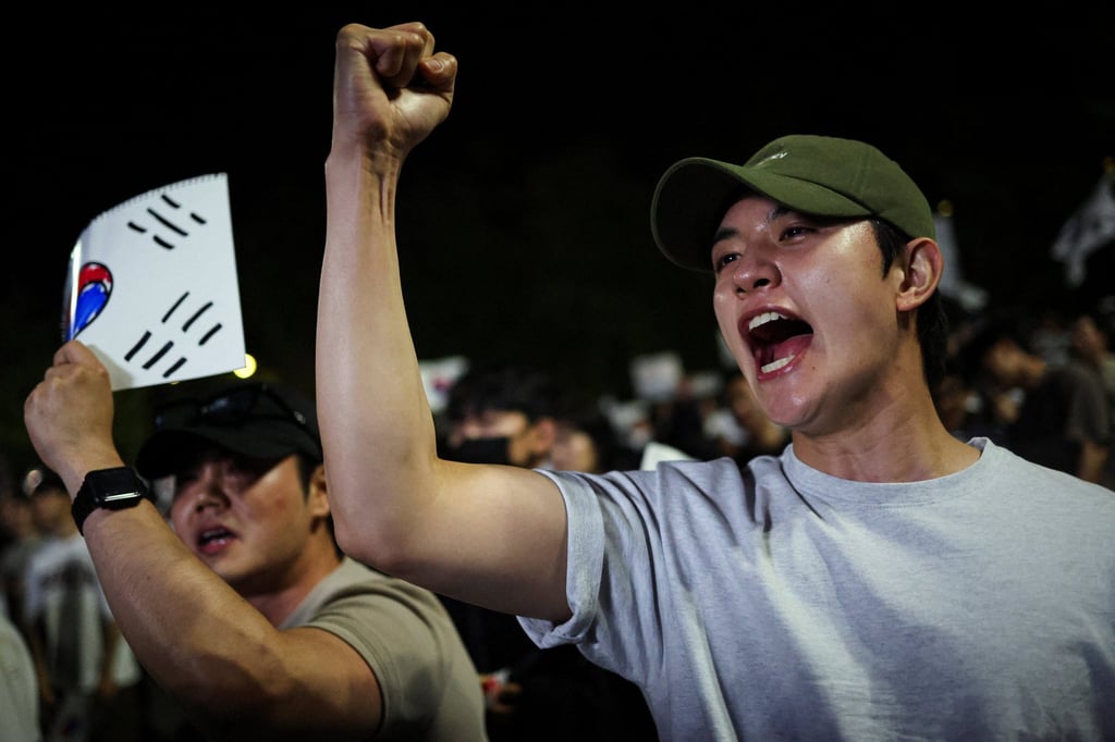 A demonstrator raises his fist as people surround a vote-counting centre during a protest in Seoul, South Korea, on Saturday. Photo: Reuters