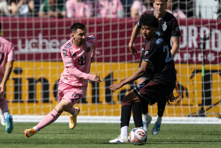Lucas Herrinton looks behind him as Lionel Messi runs behind him