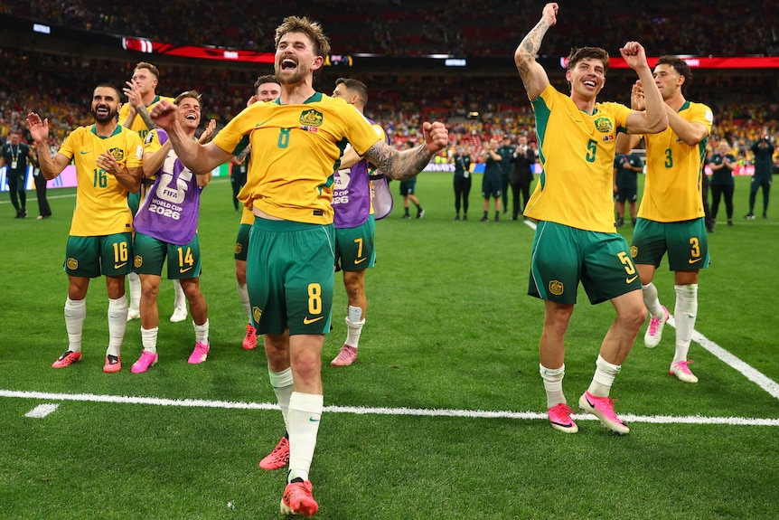 Connor Metcalfe celebrates with his Socceroos teammates.