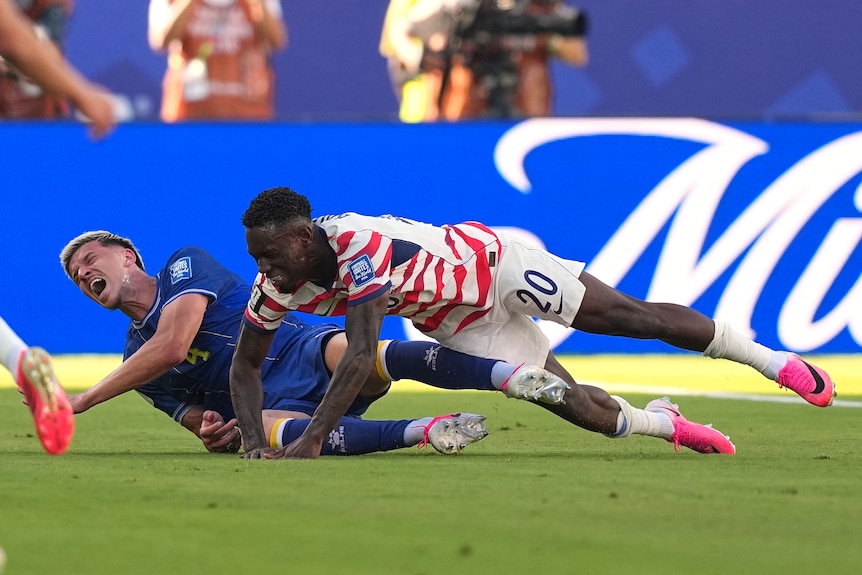 Tarik Muharemović and Folarin Balogun falling to the ground.