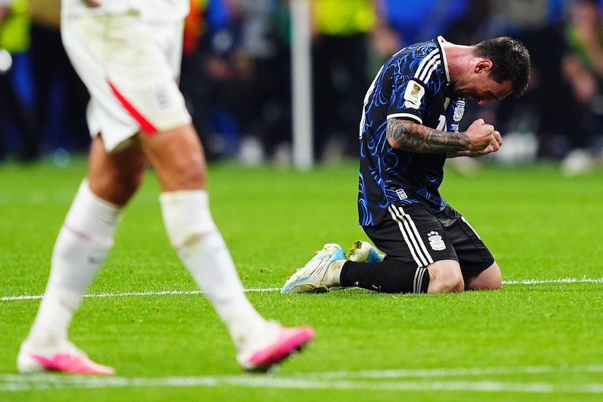 Lionel Messi drops to his knees in celebration.