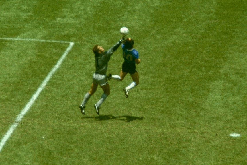 Diego Maradona uses his left arm to score past England goalkeeper Peter Shilton.