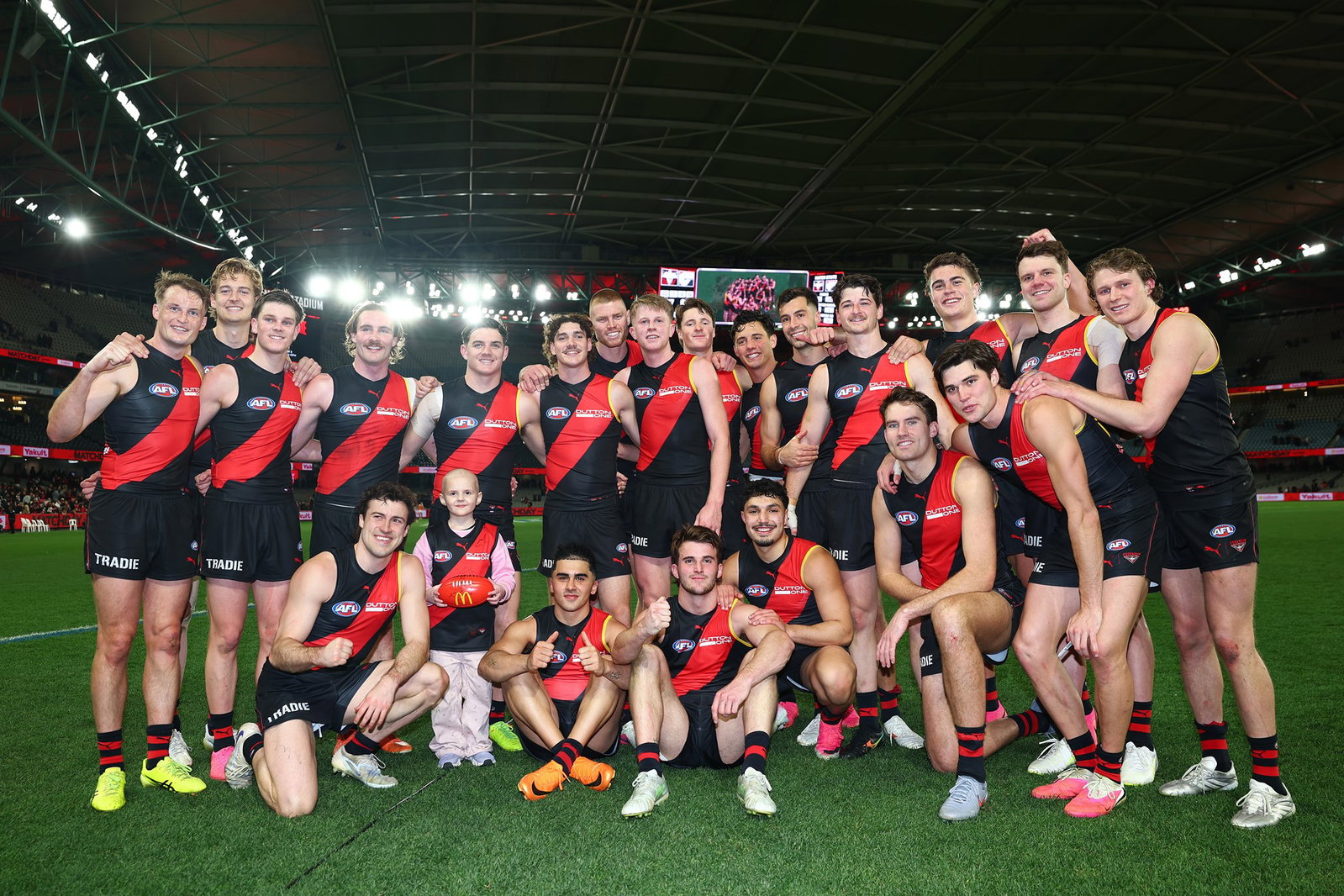 Essendon players pose after recording just their second win of the season.