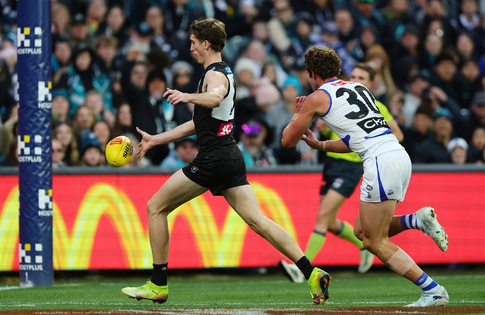 Jack Whitlock of the Power kicks a goal from Charlie Comben of the Kangaroos during the 2026 AFL Round 17 match between the Port Adelaide Power and the North Melbourne Kangaroos at Adelaide Oval on July 5, 2026 in Adelaide, Australia.