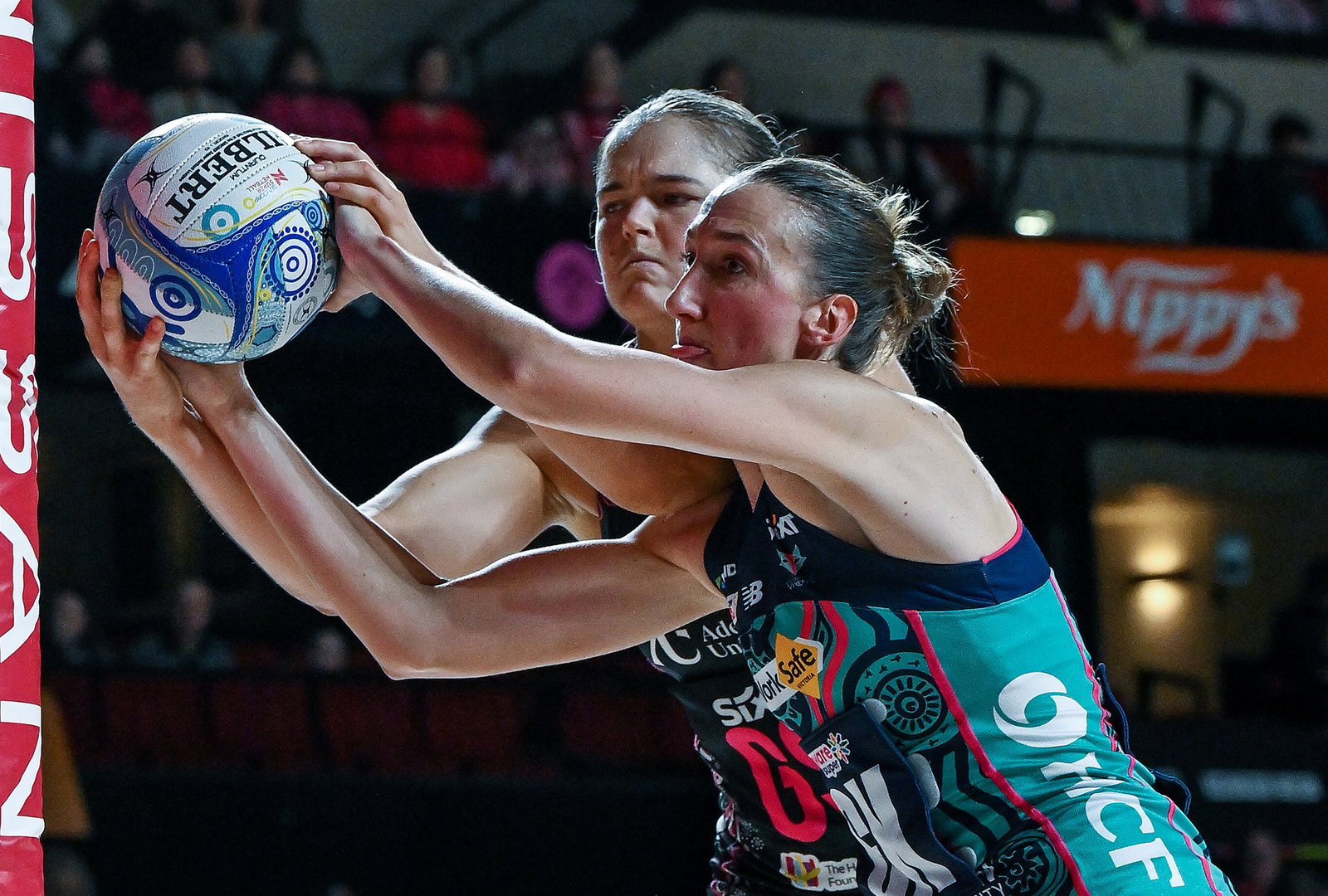 Two players closely contest the ball with both hands.