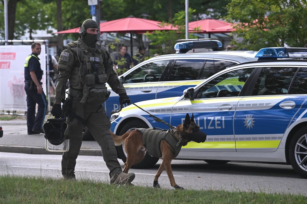 An officer and police dog are seen near a bank branch in Regensburg, Germany, where a man was fatally stabbed on Thursday. Photo: dpa An officer and police dog are seen near a bank branch in Regensburg, Germany, where a man was fatally stabbed on Thursday. Photo: dpa