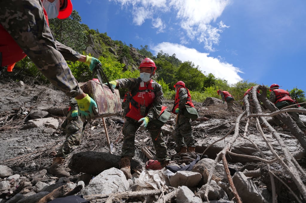 Chinese People’s Armed Police officers clear debris near Gyirong Port on Friday. Photo: China Daily via Reuters