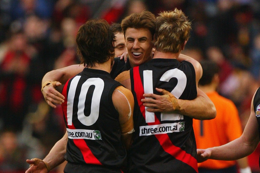 Matthew Lloyd shares a hug with Mark McVeigh and Andrew Welsh