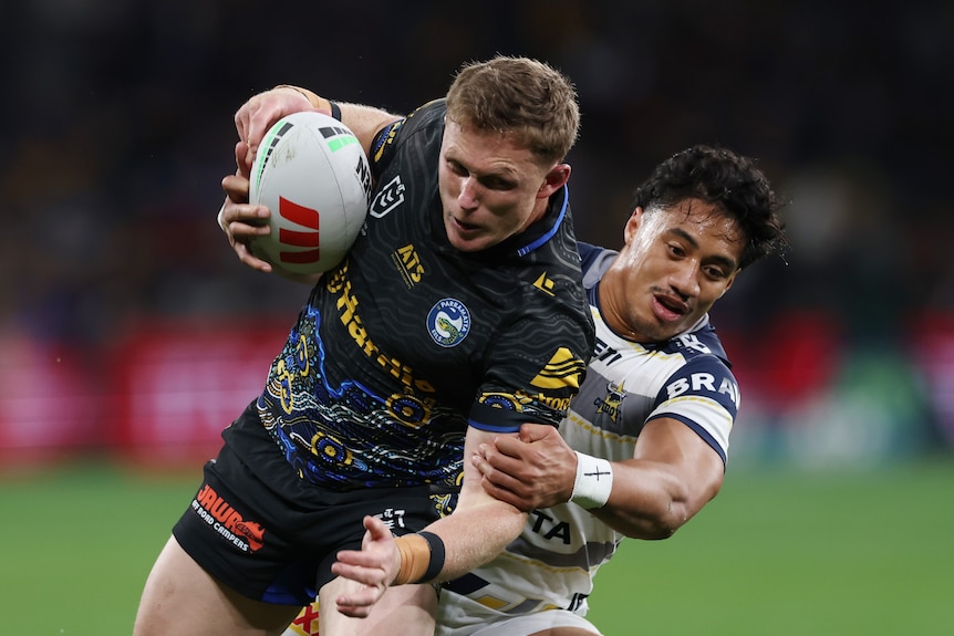 Jack Williams of the Eels is tackled around the body