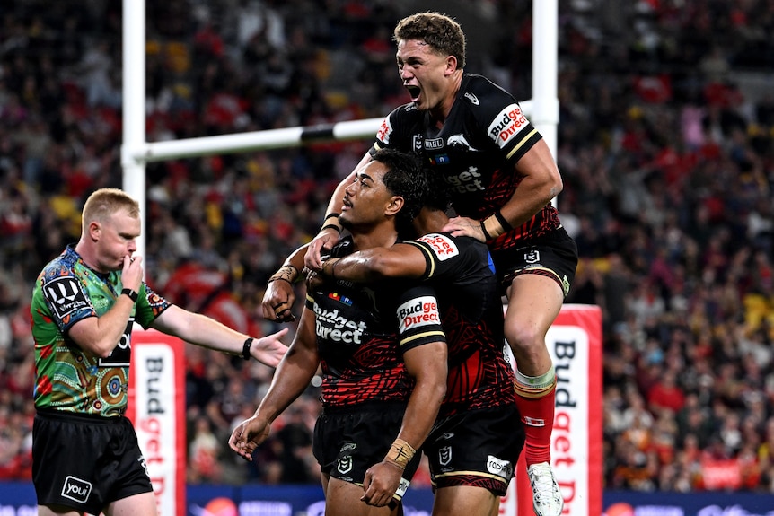 Two rugby league players in red and black celebrate a try