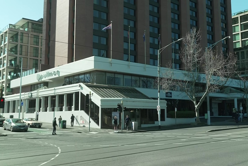 A multi-storey building on a city street corner with a sign that says "Pullman".