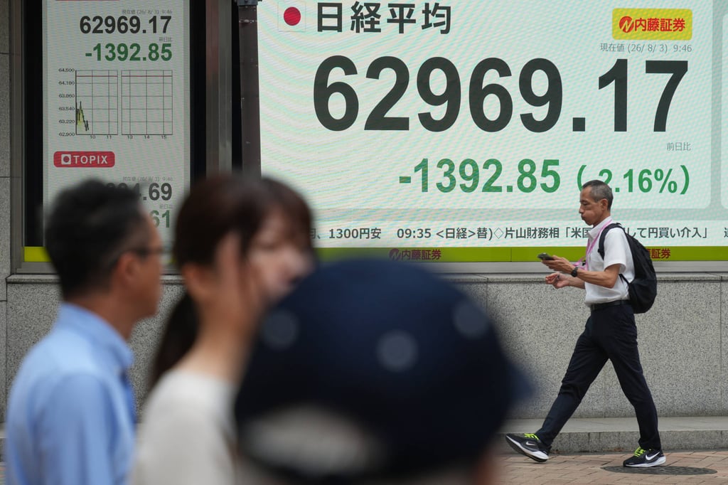 A person walks past an electronic board showing the US dollar and Japanese yen exchange rate at a securities firm in Tokyo on August 3, after the US and Japan launched a coordinated operation to prop up the Japanese currency. Photo: AP