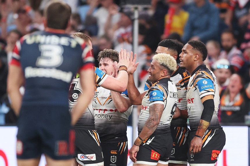 A man celebrates after scoring a try in a rugby league match 