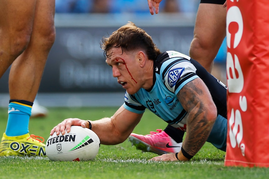 A man scores a try in a rugby league match 
