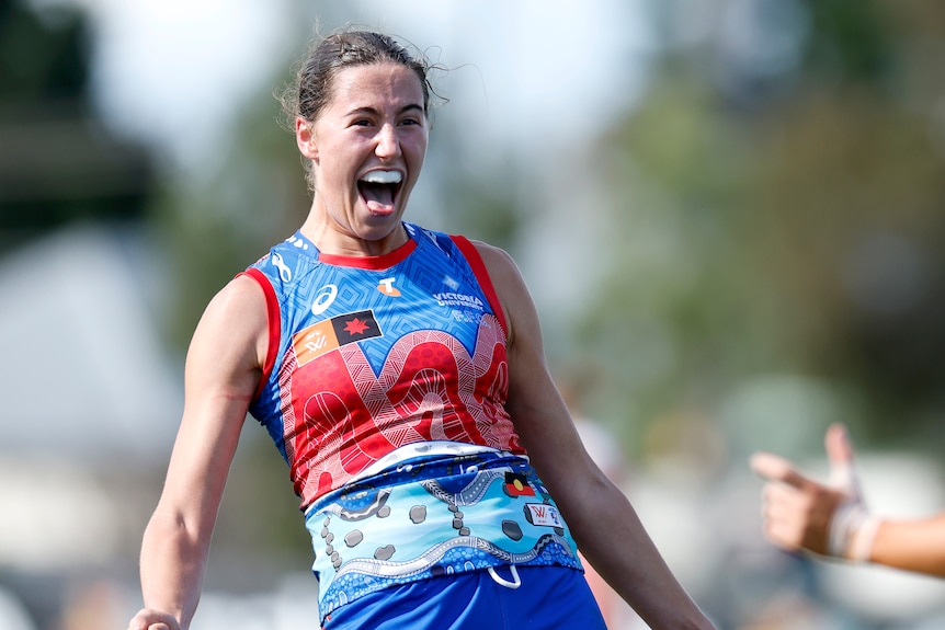 AFLW player yells while celebrating a goal.
