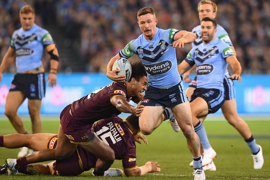 A man runs the ball during a State of Origin match