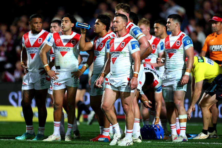 A man stands with his rugby league team after conceding a try