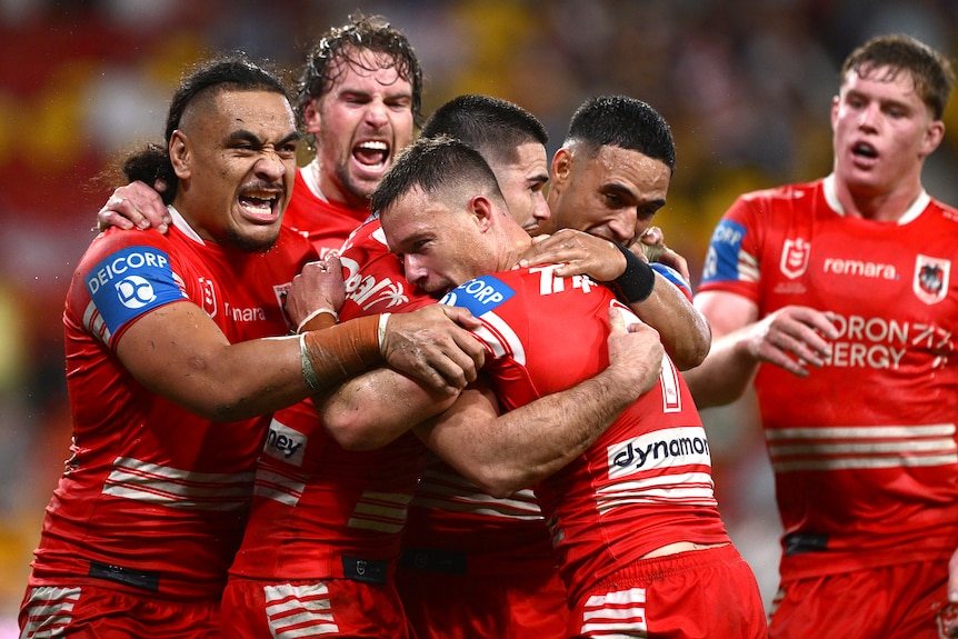 Damien Cook and Dragons teammates embrace during a 2026 NRL match.