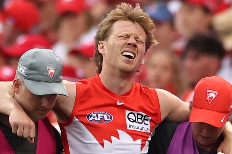 Callum Mills grimaces as he is helped off the field by physios