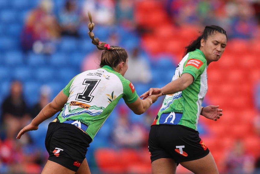 A woman celebrates after kicking a field goal 