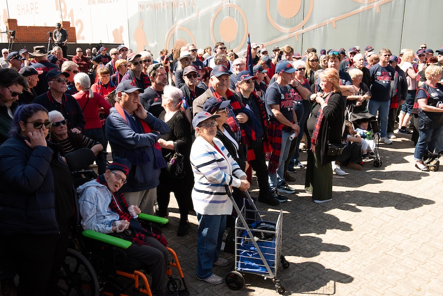 A crowd of people wearing red and blue