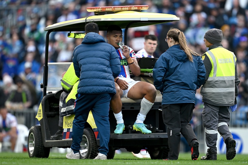 A man is taken from an NRL field after being injured. 