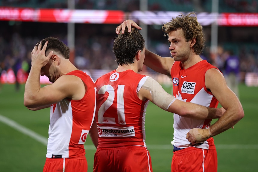 Three Sydney players console each other after losing a match