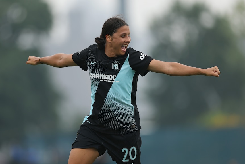 Gotham FC player Sam Kerr celebrates with a smile and arms outstretched after her team scores