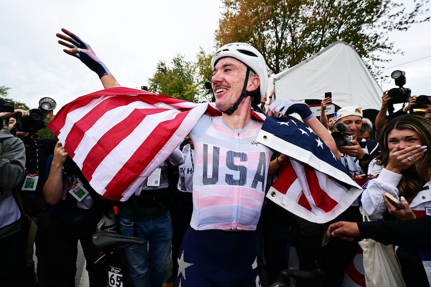 Brandon McNulty wears a USA flag and holds up his hand