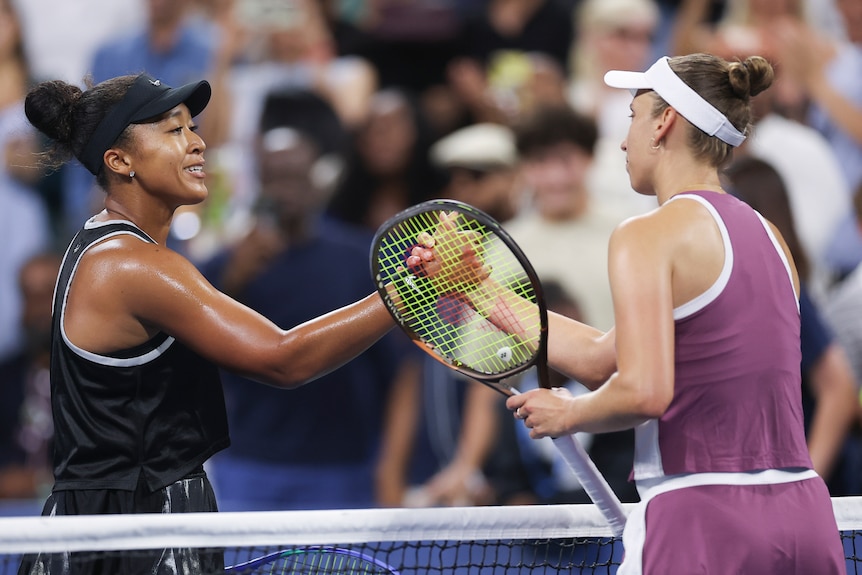 Naomi Osaka and Elise Mertens greet each other at the net.