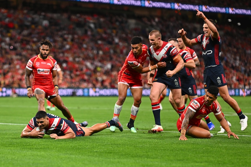 A man celebrates a try during a rugby league match 