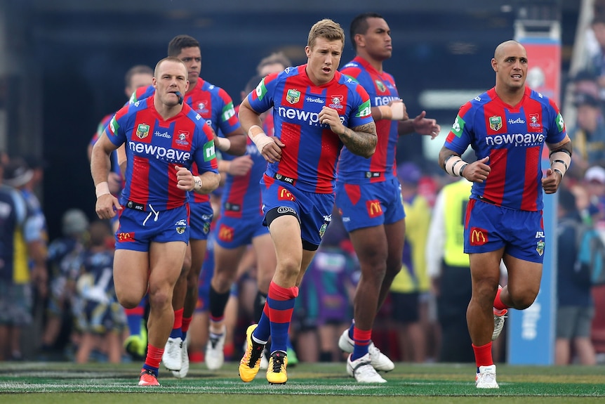 A man leads out an NRL team for a match 