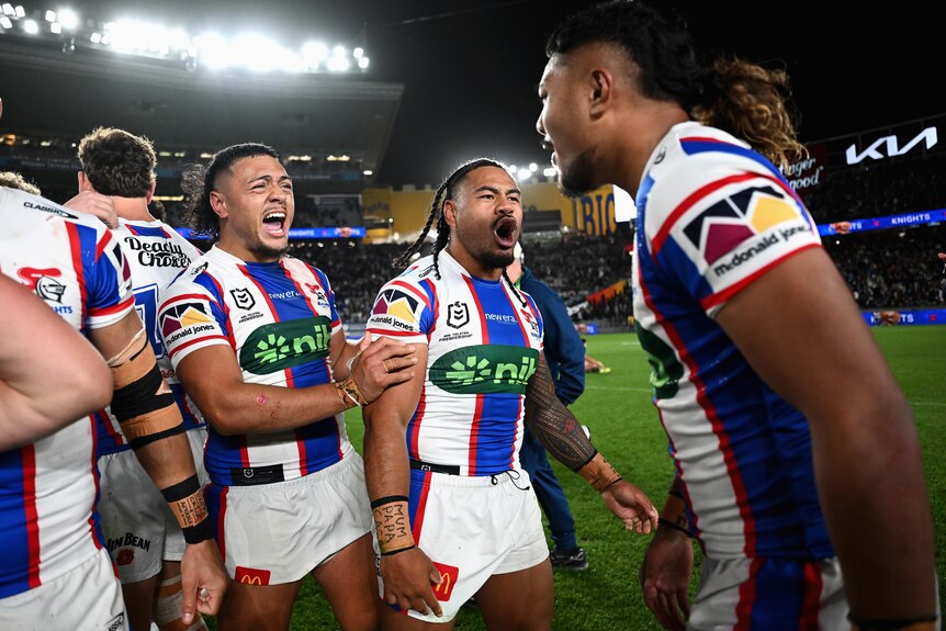 A group of players celebrate an NRL finals win