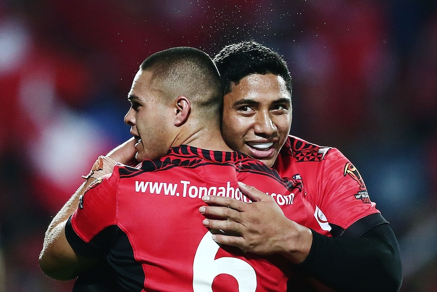 Jason Taumalolo and Tui Lolohea celebrate winning a rugby league match.