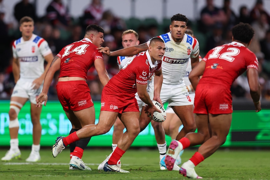 Tui Lolohea passes the ball during a rugby league match.