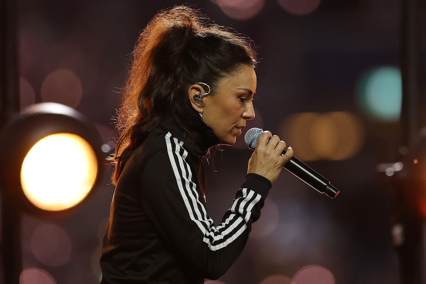 Amy Shark singing in an outdoor stadium