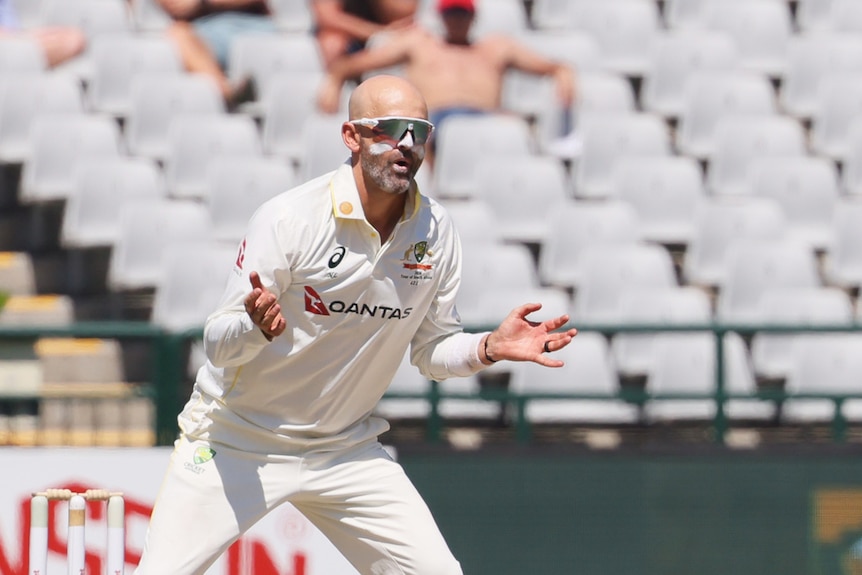 Nathan Lyon holds out his hands