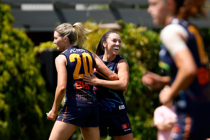 Sisters Niamh and Grace Kelly of the Adelaide Crows hug after an AFLW goal.