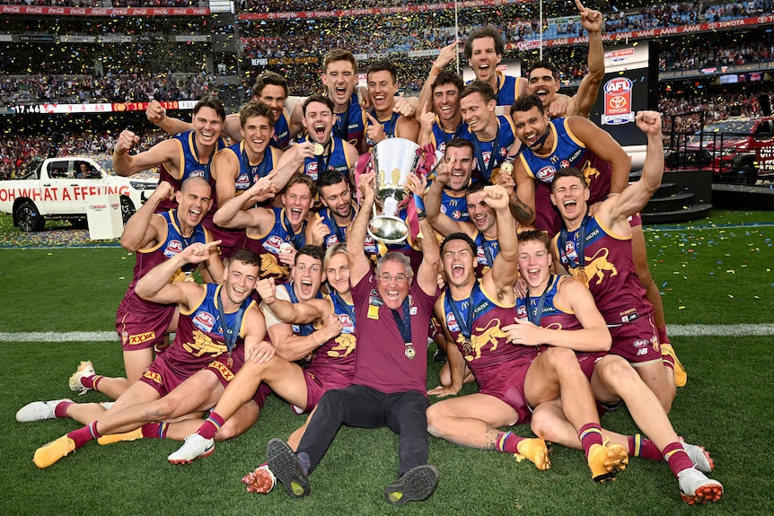 The Brisbane Lions celebrate with the AFL premiership trophy.
