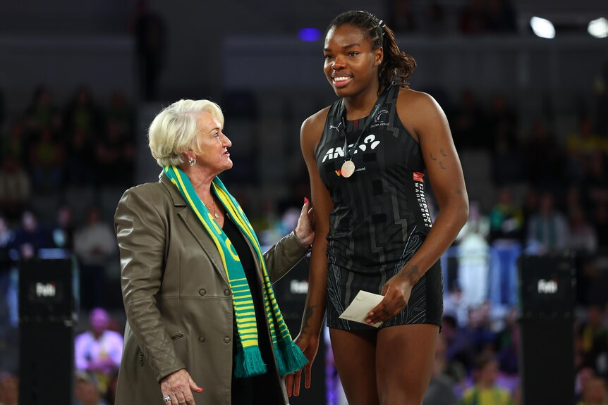 A player is handed a medal by a legend of the game