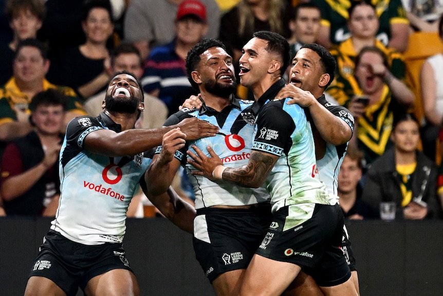 Taane Milne of Fiji celebrates with teammates after scoring a WOrld Cup try against Australia.